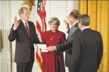  ?? Bettmann Archive 1988 ?? Anthony Kennedy (left), with wife Mary and President Ronald Reagan (right) looking on, takes the oath from Chief Justice William Rehnquist to serve on the U.S. Supreme Court in 1988.