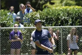  ?? DAVID J. PHILLIP ?? Fans stand behind a fence as Jon Rahm, of Spain, watches his tee shot on the second hole during the first round of the Charles Schwab Challenge golf tournament at the Colonial Country Club in Fort Worth, Texas, Thursday, June 11, 2020.