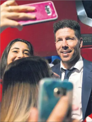  ??  ?? QUERIDO. El Cholo, haciéndose fotos con la afición, que le idolatra. El club también quiere que siga.