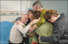  ?? ISRAELI ARMY VIA AP ?? Luis Har, left, is hugged by relatives Monday at the Sheba Medical Center in Ramat Gan, Israel, after being rescued from captivity in the Gaza Strip. Israeli forces rescued Har and another hostage early Monday, storming a heavily guarded apartment in the Gaza Strip and extracting the captives under fire in a dramatic raid. Har and Simon Marman were taken hostage by Hamas in cross-border attack in October last year.