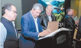  ??  ?? • Alan Aguirre Ibarra firma su libro 'Aros-Yaqui, las venas de Sonora', luego de la petición de las personas.