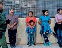  ??  ?? LONG WAIT FOR REGISTRATI­ON: Migrants wait to board a van which will take them to a processing center, in El Paso, Texas.