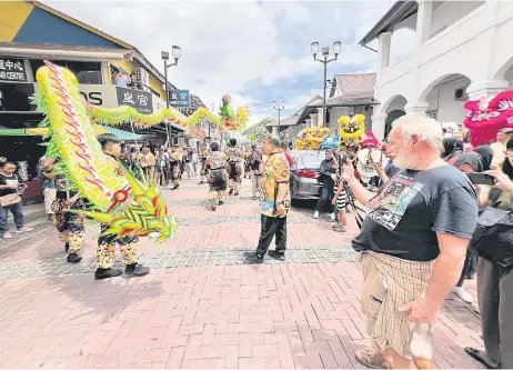  ?? – Photo by Roystein Emmor ?? A dragon dance troupe entertains the crowd along India Street.