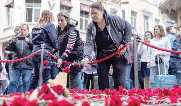  ?? Reuters ?? ↑
People lay flowers to pay tribute to the victims of a Sunday’s blast that took place on Istiklal Avenue in Istanbul on Monday.