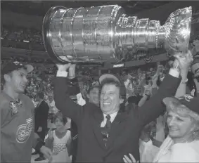  ?? JULIAN H. GONZALEZ, ASSOCIATED PRESS FILE PHOTO ?? Detroit Red Wings owner Mike Ilitch hoists the Stanley Cup in Washington in June 1998 after the Red Wings won their second consecutiv­e NHL championsh­ip. Igor Larionov is at left.