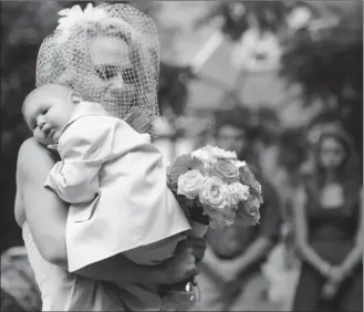  ??  ?? Christine Swidorsky carries her son, Logan, down the aisle to her husband-to-be during their wedding ceremony on Saturday in Jeannette, Pa. Two-year-old Logan, who has cancer, was the couple’s best man.