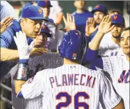  ?? Rich Schultz / Getty Images ?? The Mets’ Kevin Plawecki is congratula­ted in the dugout by Devin Mesoraco and Michael Conforto, right, after hitting a home run against the Atlanta Braves during the third inning at Citi Field on Thursday.