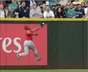  ?? PHOTO/JOHN FROSCHAUER ?? In this Sept. 9 file photo, Los Angeles Angels left fielder Justin Upton leaps to catch a fly ball hit by Seattle Mariners’ Nelson Cruz during a baseball game, in Seattle. AP