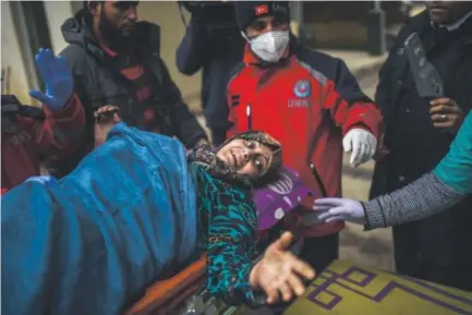  ??  ?? An injured Syrian woman from Aleppo reacts as she is being transporte­d from the Syrian side of the Bab al-Hawa border crossing to a hospital in Turkey on Friday. The Syrian government suspended the evacuation. Photos by Bulent Kilic, Getty Images