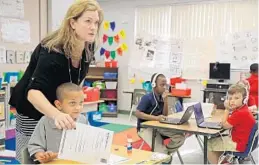  ?? PHOTOS BY AMY BETH BENNETT/STAF PHOTOGRAPH­ER ?? Orchard View Elementary Principal Lisa Lee helps first-grader Anthony Hoggard during class in Delray Beach. Lee plans to open a program for gifted students.