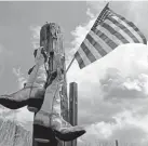  ??  ?? An American flag and an old pair of cowboy boots hang on a fence post along Colorado Road 131 during Stage 1 of the Colorado Classic on Thursday.