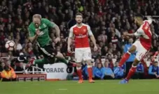  ?? MATT DUNHAM/THE ASSOCIATED PRESS ?? Arsenal’s Theo Walcott takes a shot at goal as Lincoln City’s Bradley Wood attempts to block it on Saturday in FA Cup play.