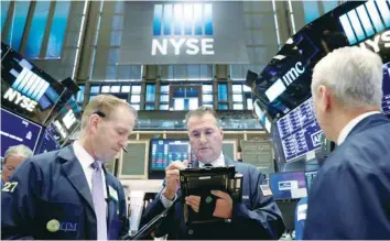  ?? — Reuters ?? Traders work on the floor of the New York Stock Exchange (NYSE) in New York.