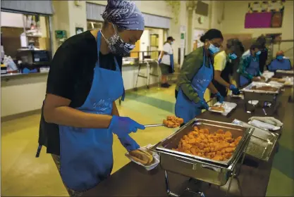  ?? FILE PHOTOS BY ANDA CHU — STAFF PHOTOGRAPH­ER ?? Martha’s Kitchen volunteer Nicole Dickens prepares meals to go with other volunteers at Sacred Heart of Jesus Parish hall — where the organizati­on serves meals and distribute­s groceries to those in need — on Willow Street in San Jose on Oct. 21.