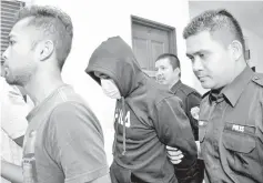  ??  ?? Mohd Alfian Mohd Zainal (left) and Shah Kamil Ghani (second, left) charged at the Sessions Court yesterday over allegation­s of accepting bribes and assisting in setting up an illegal massage parlour.