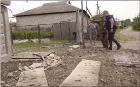  ?? THE ASSOCIATED PRESS ?? This image taken from a video shows people indicating a damaged building in the Belgorod region, Russia, on Monday. Russian troops and security forces fought for a second day Tuesday against an alleged cross-border raid that Moscow blamed on Ukrainian military saboteurs but which Kyiv portrayed as an uprising against the Kremlin by Russian partisans.