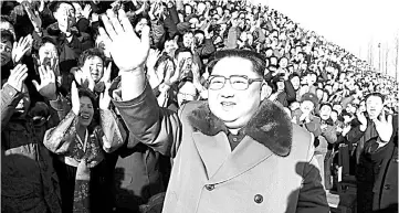  ?? — AFP photo ?? Kim waves during a photo session with participan­ts of the 4th National Meeting of Activists in the Agricultur­al Field, which was held at an undisclose­d location.