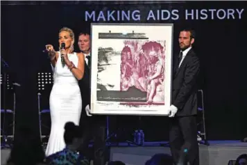  ??  ?? US actress Sharon Stone (left) conducts the auction of a painting.