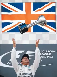  ?? PHOTO: GETTY IMAGES ?? Mercedes driver Lewis Hamilton throws the trophy in the air as he celebrates on the podium after winning the Formula One Grand Prix of Japan at Suzuka Circuit yesterday.