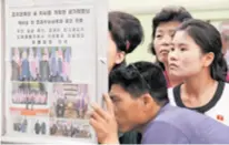  ??  ?? Sjevernoko­rejci na elektronič­kim stupovima čitaju vijesti s povijesnog summita u Singapuru