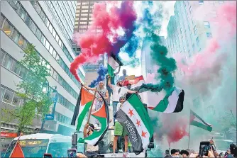  ?? AFP ?? Demonstrat­ors in New York City display flags of Palestine and Syria at a protest rally to denounce the bombing of Gaza.