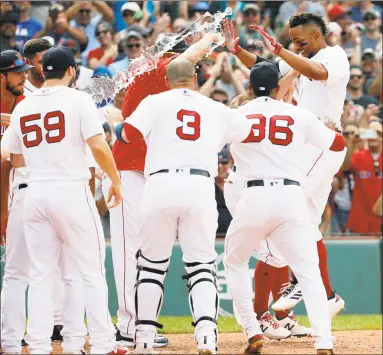 ?? Winslow Townson / Associated Press ?? Xander Bogaerts, right, is greeted by teammates at home plate after hitting a grand slam in the 10th inning against the Blue Jays on Saturday.