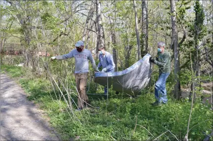  ?? RACHEL RAVINA — MEDIANEWS GROUP ?? A trio of volunteers participat­ing in the 51st annual Wissahicko­n Creek Clean Up carry a discarded mattress from the banks of Wissahicko­n Creek on Saturday morning near the Four Mills Nature Reserve in Ambler.