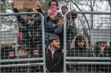  ??  ?? Migrants wait in a buffer zone at the Turkey-Greece border.