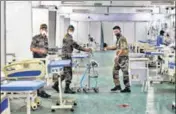  ?? ANI ?? Security personnel arrange a room for patients at DRDO’s Covid care centre in Delhi Cantonment in New Delhi.