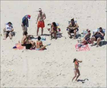  ?? ANDREW MILLS — NJ ADVANCE MEDIA (VIA AP) ?? New Jersey Gov. Chris Christie, seated at far right, is shown with family members Sunday at Island Beach State Park in New Jersey.