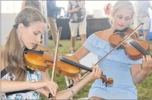  ?? MITCH MACDONALD/THE GUARDIAN ?? Sisters, from left, Zoe and Holly O’Regan perform during the ninth annual Mermaid Tears Sea Glass Festival at the Souris Lighthouse grounds last weekend.