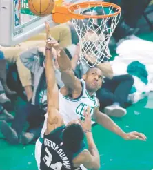  ??  ?? Al Horford trata de bloquear un disparo al alero Giannis Antetokoun­mpo en la apertura de los playoffs.