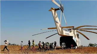  ?? PHOTO: REUTERS ?? Men unload boxes of nutritiona­l supplement­s from an helicopter prior to a humanitari­an food distributi­on carried out by the United Nations World Food Programme in Thonyor, Leer county, South Sudan.