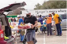  ?? MARIE D. DE JESUS/HOUSTON CHRONICLE ?? Volunteer Enrique Albi loads food into a vehicle Sunday during a food distributi­on event. The Houston area was depleted of resources in the aftermath of a winter storm.