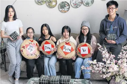  ?? CINDY NGUYEN • THE GUARDIAN ?? Some young Vietnamese Islanders, from left, Tracy Nguyen, Brenda Tran, Chau Nguyen, Lee Nguyen, Layla Do and Zack Nguyen, say they’re excited to be able to make Chung cake, a traditiona­l dish on Lunar New Year, with family members even during the pandemic.