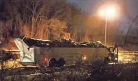  ?? KEVIN HAGEN/AP ?? Several teenage passengers were injured when a bus hit an overpass that peeled off the vehicle’s roof Sunday in Lakeview, N.Y.