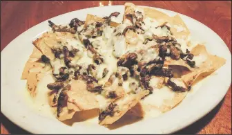  ?? DEREK OXFORD/NWA DEMOCRATGAZETTE ?? The fajita nachos include a choice of fajita meat and white queso smothering a pile of La Huerta’s house-made tortilla chips.