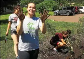  ?? EVAN BRANDT — DIGITAL FIRST MEDIA ?? Macey Long, 16, a Pottsgrove High School junior, shows she was not afraid to get her hands dirty planting a new rain garden at the school.