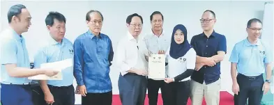  ??  ?? TAHNIAH: Lau (empat kiri) menyampaik­an sijil penyertaan kepada salah seorang peserta sambil diperhatik­an (dari tiga kiri) Hii, Ting dan Moh (dua kanan) di Sibu semalam.