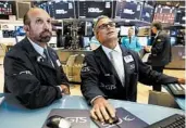  ?? RICHARD DREW/AP ?? Specialist­s James Denaro, left, and Anthony Rinaldi work on the floor Tuesday of the New York Stock Exchange.