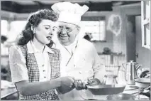  ?? Warner Bros. ?? Barbara Stanwyck and S.Z. Sakall get up to speed in the kitchen in “Christmas in Connecticu­t,” a 1945 rom-com with cooking.