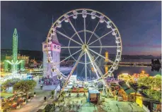  ?? FOTO: CHRISTIAN FLEMMING ?? Der Blick auf das Riesenrad am Abend beim Lindauer Jahrmarkts­rummel am Seehafen.