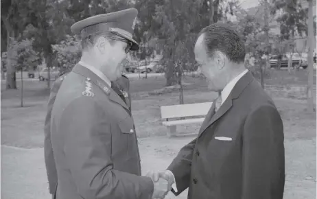  ?? ?? Dimitris Ioannidis (l) and Georgios Papadopoul­os shake hands at Easter in April 1973. Seven months later, the hardline brigadier overthrew Papadopoul­os in a countercou­p.