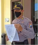  ?? EDI SUDRAJAT/JAWA POS ?? SAKIT HATI: Kasatsabha­ra Polres Blitar AKP Agus Hendro Tri Susetyo menunjukka­n surat pengajuan mundur sebagai polisi di Mapolda Jatim kemarin.