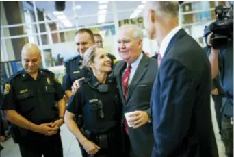  ?? WILL VRAGOVIC/TAMPA BAY TIMES VIA AP ?? Tampa Mayor Bob Buckhorn, center right, hugs Tampa Police Officer Randi Whitney at Tampa Police Headquarte­rs in Tampa, Fla., Wednesday, as he and Florida Gov. Rick Scott congratula­te her on the arrest of a suspect in the Seminole Heights killings.