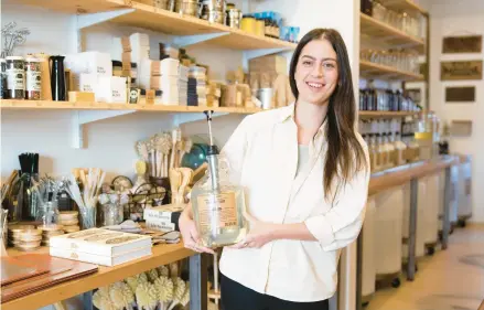  ?? MATT ROURKE/AP ?? Emily Rodia holds concentrat­ed laundry soap that customers can pump into their own refillable containers at her store in Philadelph­ia.