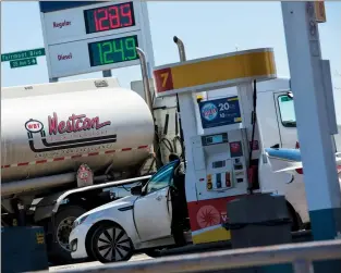  ?? Herald photo by Ian Martens @IMartensHe­rald ?? A motorist moves to the pumps while a fuel delivery truck prepares to leave from a gas station Tuesday afternoon on the city’s southside. Prices have jumped recently and are expected to climb heading into the summer driving season.