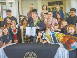  ?? Photo courtesy office of the governor ?? Hawaii Governor Josh Green (center left), signed legislatio­n designatin­g an official state kāhuli, or snail, for each of the main Hawaiian islands, as well as the Northweste­rn Hawaiian Islands on Friday.