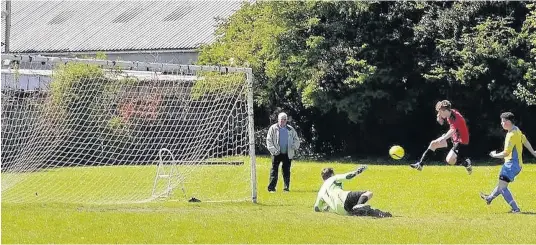  ??  ?? Bro Goronwy’s Callum Thomas high kicks the opening goal against Rhyl Town last Saturday