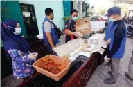  ?? ANGGER BONDAN/JAWA POS ?? DAPUR UMUM: Pegawai Dinas Sosial Sidoarjo menyiapkan 100 boks makanan untuk para pasien isolasi mandiri di selter kemarin.